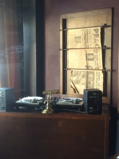 A turntable with old newspapers behind it