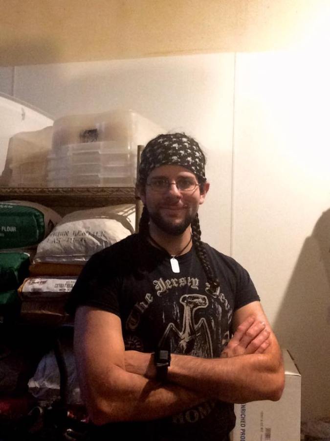 The author posing with arms crossed next to a shelf of flour.