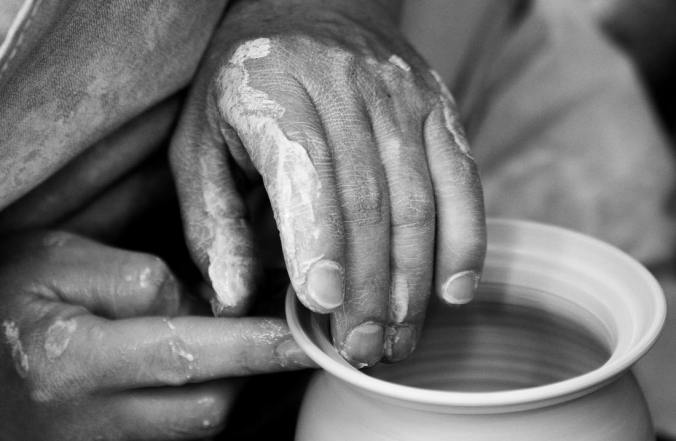 close up of hands making a clay pot