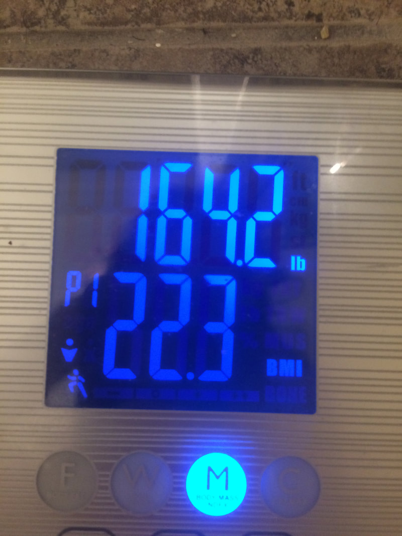 Scale readout indicating 164.2 pounds and a BMI of 22.3