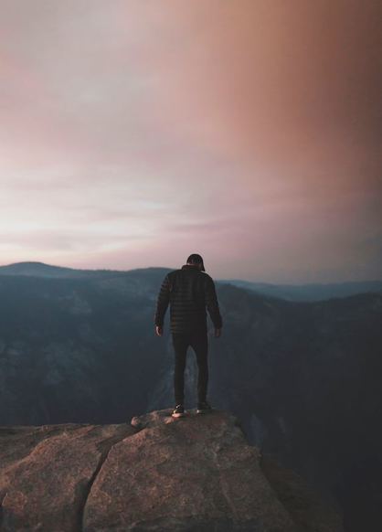 Man standing on top of a mountain at dusk in Yosemite
