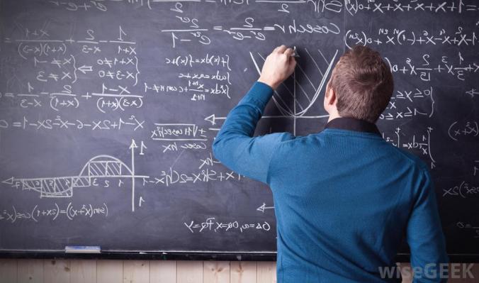 Teacher writing equations on chalkboard