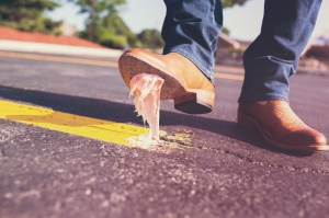 Close up of a man in nice boots who just stepped in gum.