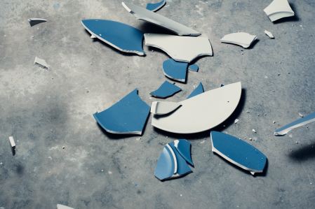 Broken blue plates on cement