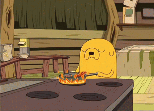 Animated GIF of Jake from Adventure Time serenely frying bacon pancakes